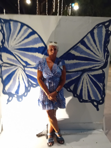 Jeni stood in front of butterfly wings paintings