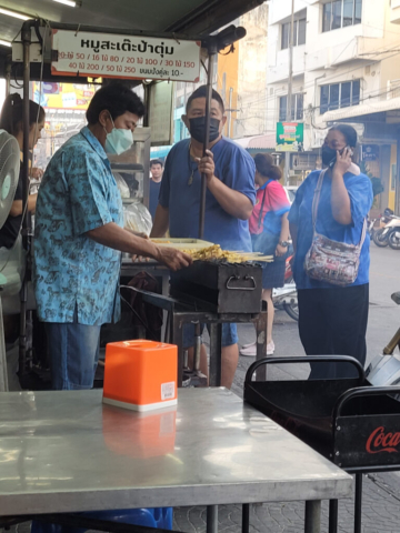 Satay sticks being cooked on the street corner